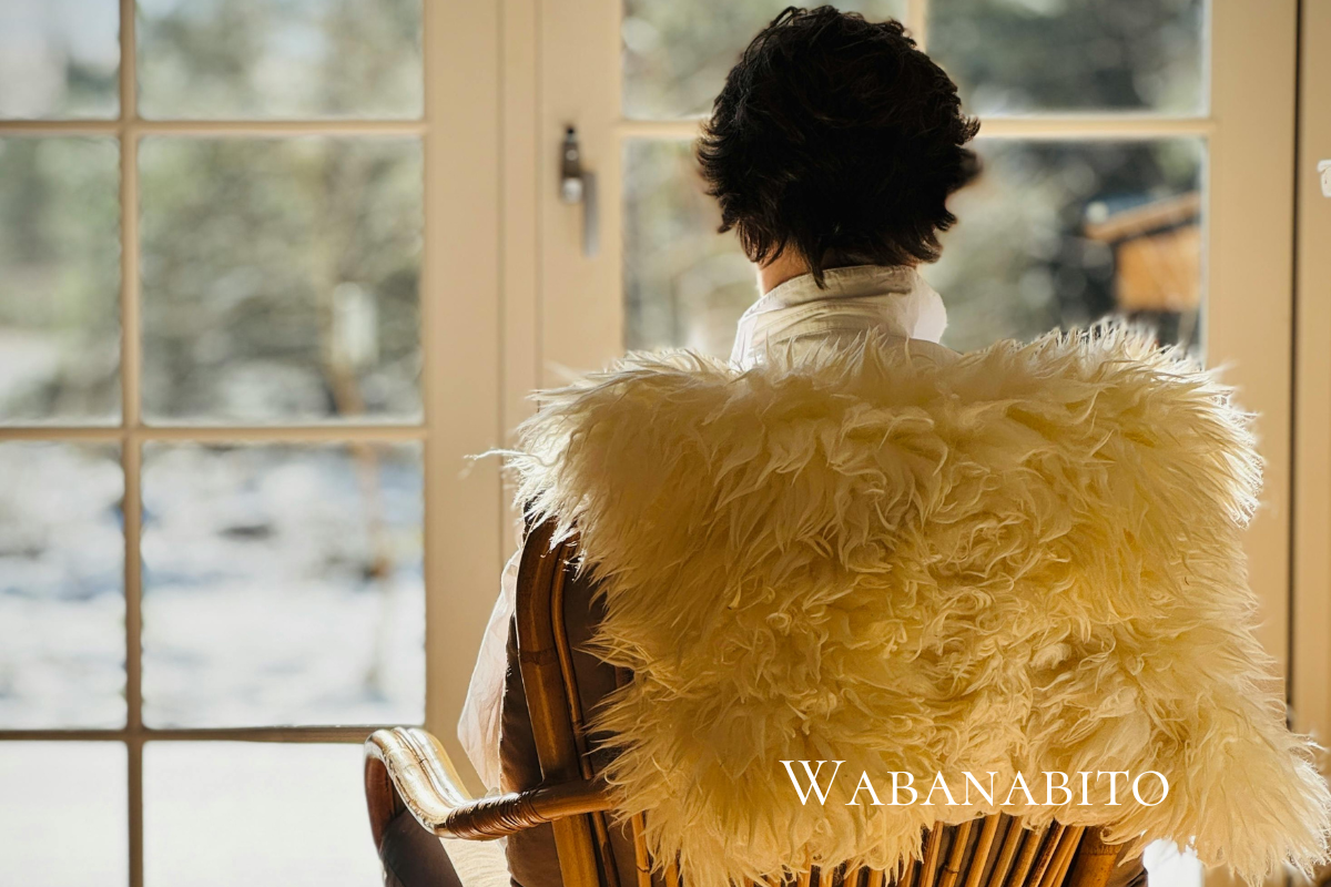 冬の景色を室内から眺める人