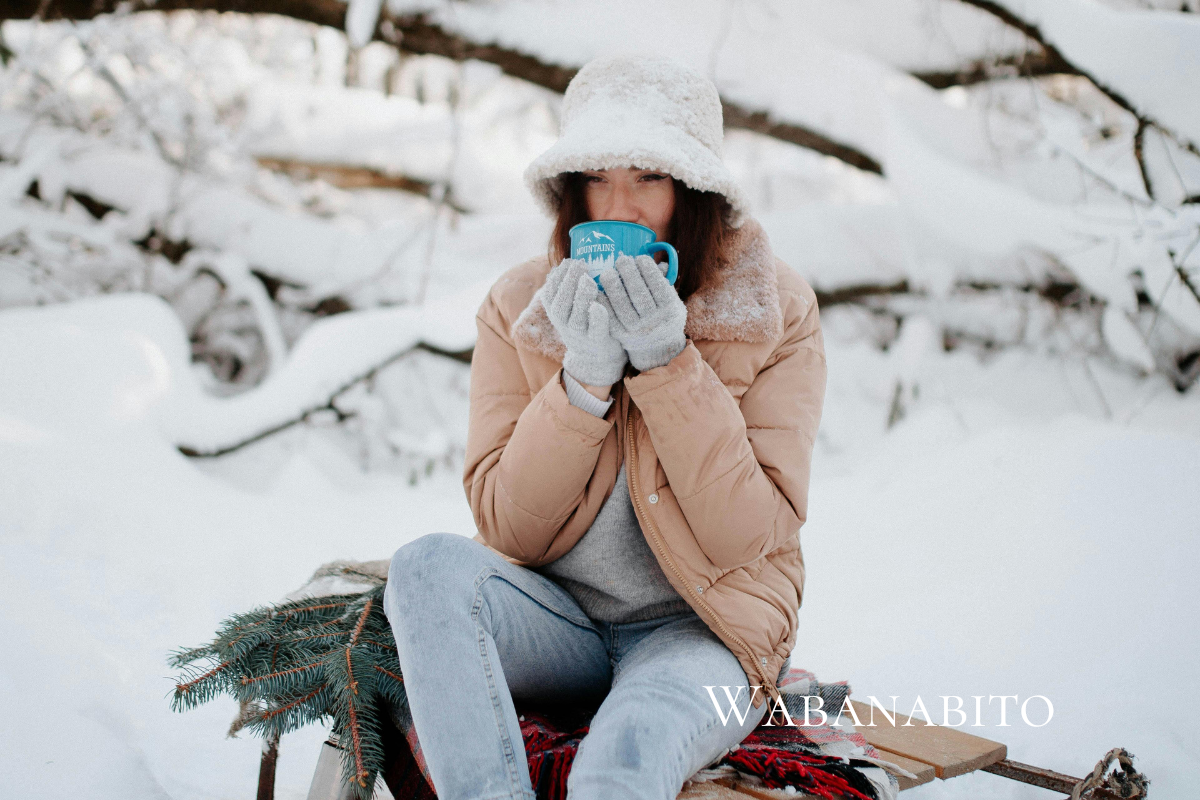冬の庭仕事の合間に温かい飲み物を飲む人